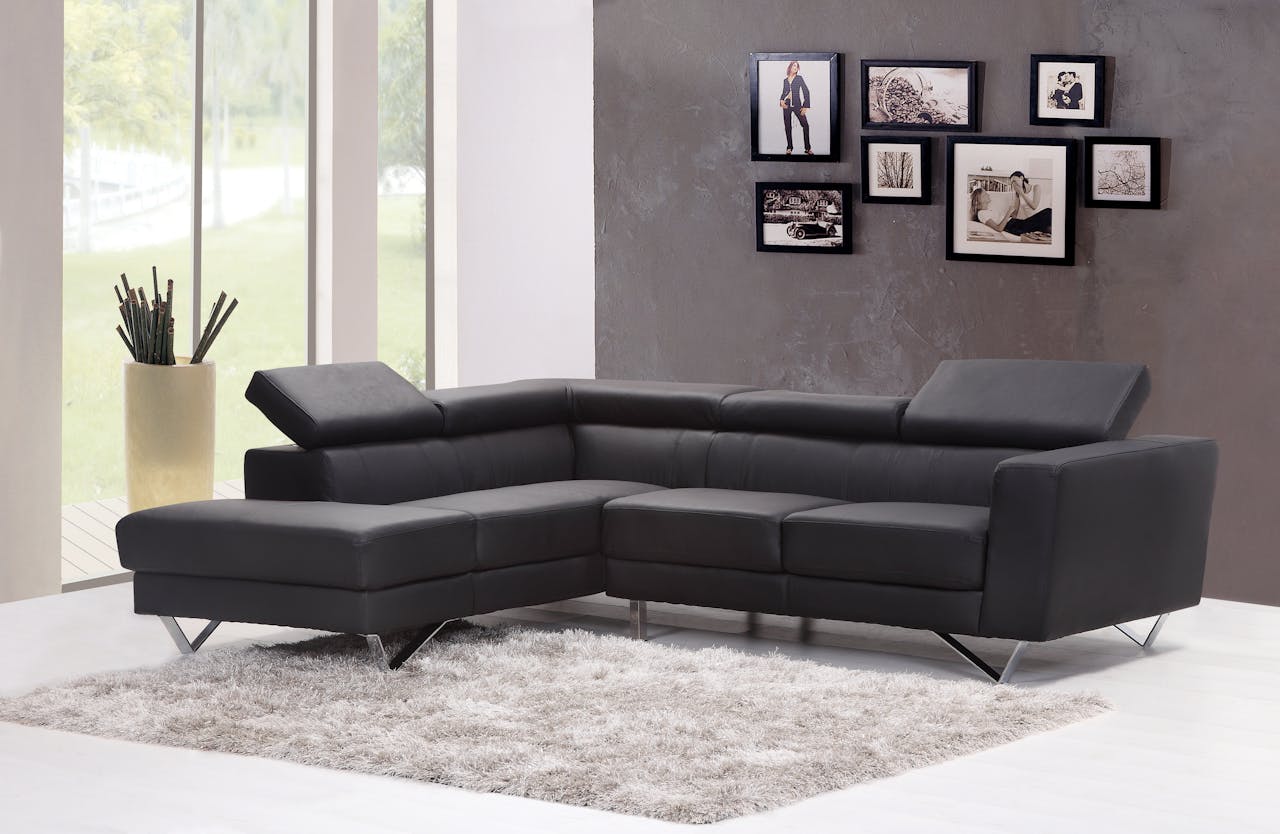 about-us Contemporary living room featuring a sleek black sectional sofa and chic wall art.